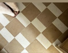 a person's feet standing on a tiled floor