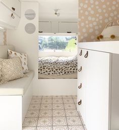 the interior of a tiny home with white furniture and polka dot wallpaper on the walls