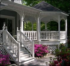 a white gazebo sitting on top of a lush green field