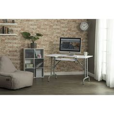 a living room with a chair, desk and computer monitor on the wall in front of it