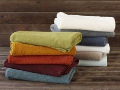 towels stacked on top of each other in different colors and sizes, with one folded over the