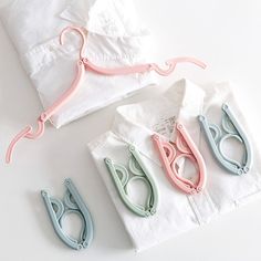 three pairs of scissors sitting on top of white napkins next to folded t - shirts