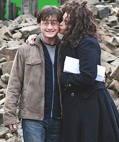 two people standing next to each other in front of rocks and buildings with the caption harry potter