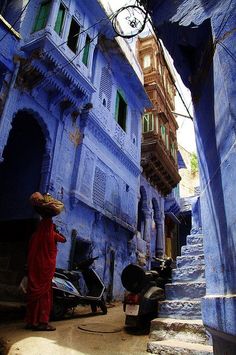 an alleyway with blue walls and steps