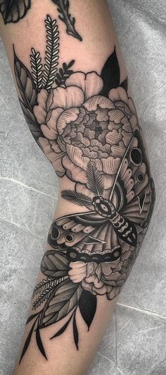 a woman's leg with flowers and scissors on her legs, in black and white