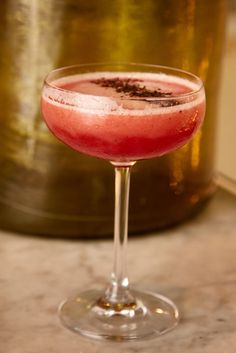 a drink in a wine glass on a table