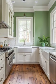 a kitchen with green walls and white cabinets