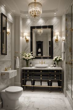 a fancy bathroom with marble floors and gold trimmings on the walls, along with an elegant chandelier