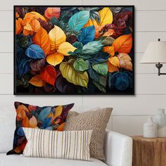 a living room scene with focus on the couch and colorful leaves framed art print on the wall