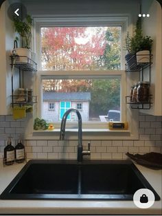 a kitchen sink sitting under a window next to a counter