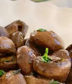 mushrooms are piled on top of each other with parsley sprigs in the middle