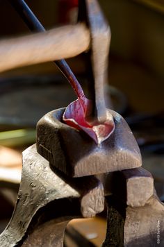 a piece of metal being worked on with a hammer and an apple slice in it