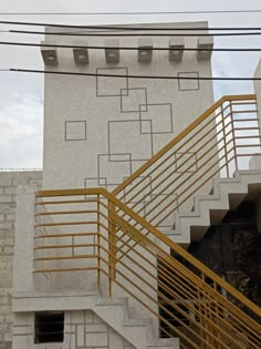 a yellow hand rail on the side of a white building next to some stairs and a fire hydrant