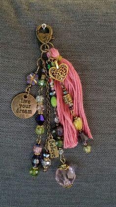 a tasseled keychain with charms and beads hanging from it's side