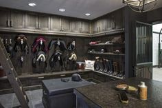 a room filled with lots of different types of hats and boots on shelves next to a ladder