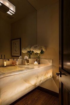 a bathroom with two sinks and flowers on the counter