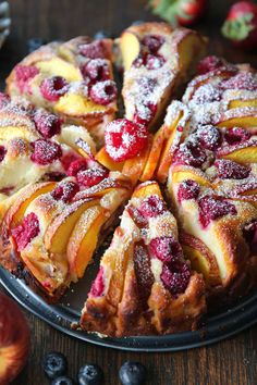 a cake with fruit toppings and powdered sugar on top