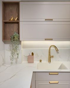 a kitchen with marble counter tops and gold faucets on the wall above the sink