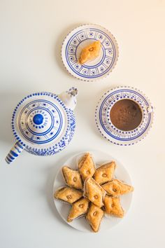 small pastries on a plate next to two teapots