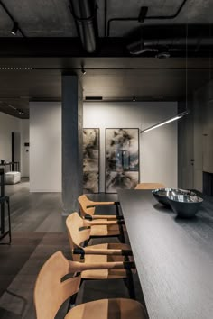 a long table with chairs and a bowl on it in the middle of a room