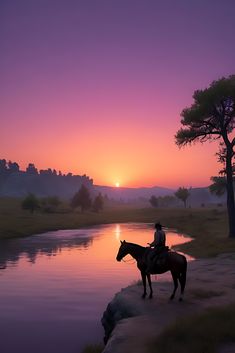 a man riding on the back of a brown horse next to a river at sunset