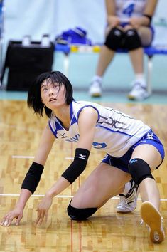 a female volleyball player crouching down on the court