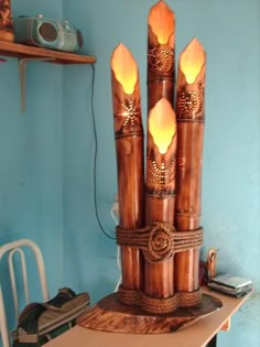 a lamp made out of wood sticks and rope with lights on them in a room