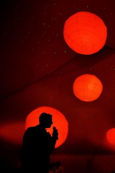 a man standing in front of red lanterns