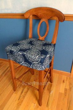 a wooden chair with a blue and white seat cover on it's backrest