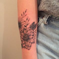 a woman's arm with a flower tattoo on it