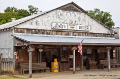 an old fashioned diner with american flags on the outside