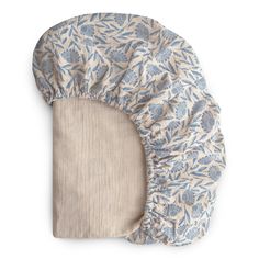 a blue and white flowered cover on top of a pillow with a beige background