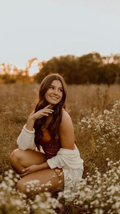 a woman sitting in the middle of a field