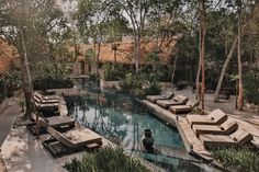 an outdoor swimming area with lounge chairs and trees