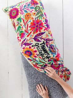 two people are hugging each other while the woman is covering them with a colorful pillow