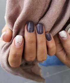 a woman's hands with purple and white manicures on their nails, holding a purse