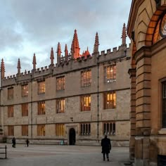 people are walking in front of a large building