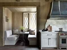 a kitchen with an oven, stove and dining table inside of it on the floor