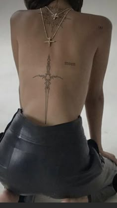 a woman with a cross tattoo on her back