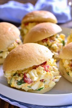 several sandwiches on a plate with eggs and cheese