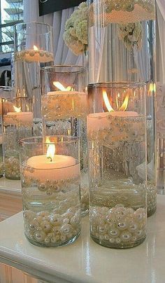 there are many vases with candles in them