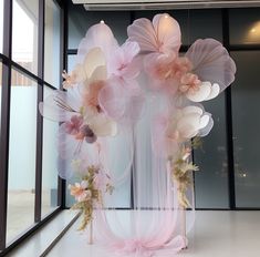 an arrangement of flowers on display in front of a window