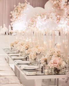 a long table with white flowers and candles