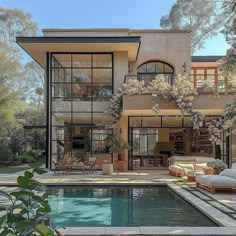 a large house with a pool in front of it and lots of windows on the side