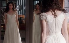 a woman in a white dress looking at herself in the mirror