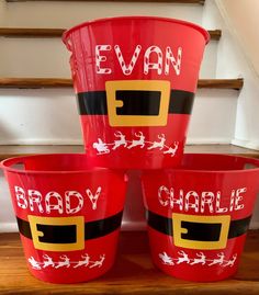 three red buckets with santa claus's face painted on them sitting in front of some stairs