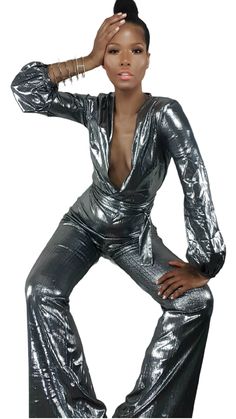 Dass jumpsuit by Nik Spruill takes glow up to the max! Form fitting silver stretch polyester material V neckline Full length bootcut hem Wrap front with belt included Back zipper Metallic Jumpsuit, Metallic Jumpsuits, V Neckline, Glow Up?, Polyester Material, Metallic Silver, Leather Pants, Full Length, Turtle Neck