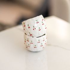 two white ceramic cups with cherries on them