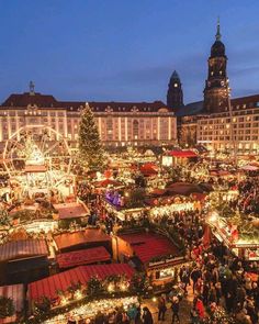 an aerial view of a christmas market in the middle of town at night with lights and decorations