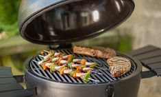 a grill with meat and vegetables cooking on it